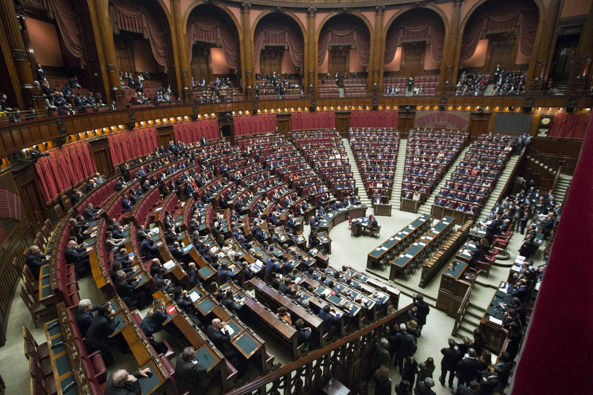 A legislative chamber with rows of seats and representatives